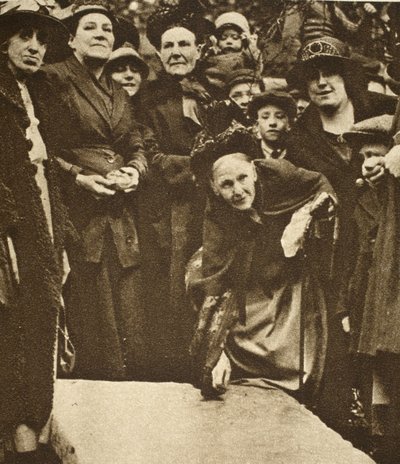 Poor widows pick up sixpences from a tombstone on Good Friday by English Photographer